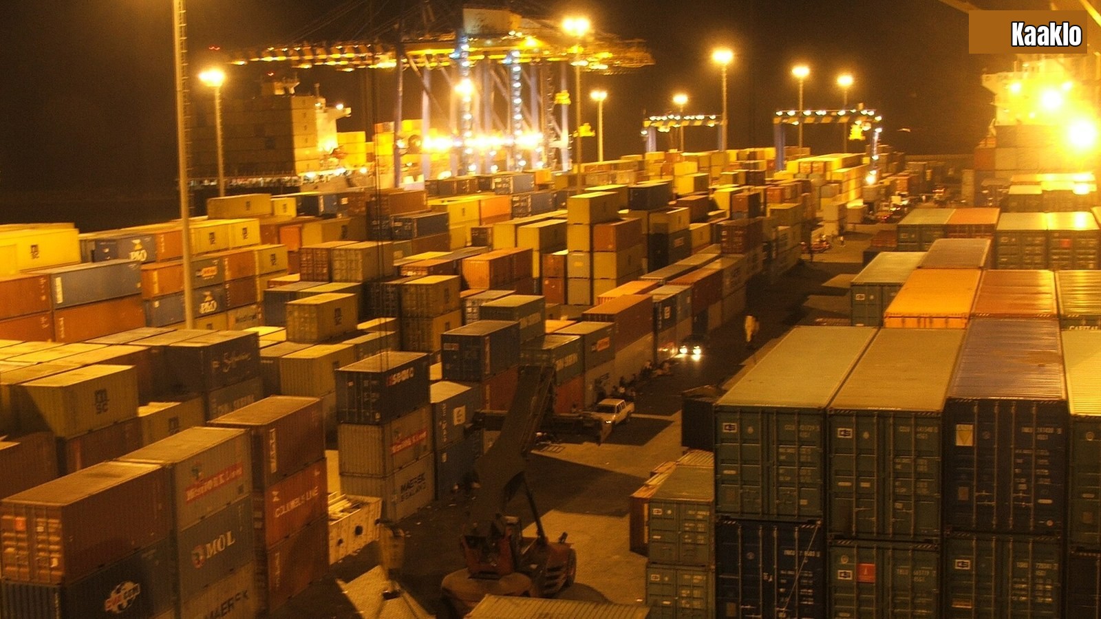 Containers stacked at night under floodlights at the Tema container terminal in Ghana.
