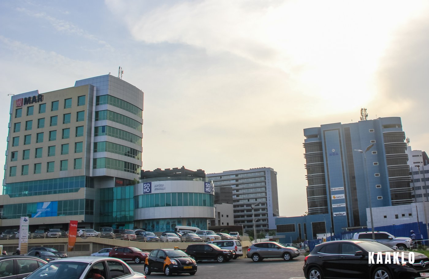 Office towers and traffic in Accra under a bright sky.