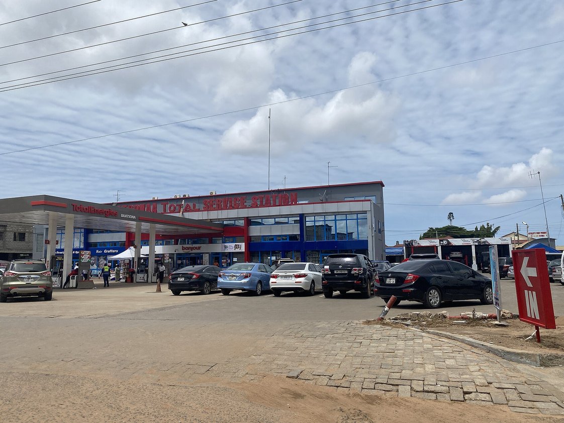 The Batsonaa Total Service Station on Spintex Road in Accra, with cars parked in front.